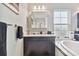 Elegant bathroom vanity featuring a sink, dark cabinets, and an adjacent soaking tub at 6317 Brevada Ln, Apollo Beach, FL 33572