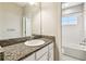 Bathroom showcasing a granite countertop vanity, tiled floors, and a shower and bath combo at 6317 Brevada Ln, Apollo Beach, FL 33572