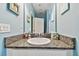 Powder room featuring granite countertop, white sink, and light blue walls at 6317 Brevada Ln, Apollo Beach, FL 33572