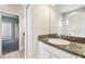 This bathroom features a granite countertop vanity with view into another bedroom at 6317 Brevada Ln, Apollo Beach, FL 33572