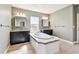 Bathroom featuring a soaking tub with tile surround and double vanities at 6317 Brevada Ln, Apollo Beach, FL 33572
