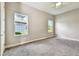 Light-filled bedroom with plush carpeting and two sun-drenched windows providing great natural light at 6317 Brevada Ln, Apollo Beach, FL 33572