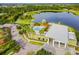 Aerial view of the community pool and clubhouse, nestled by a lake with playground and well-manicured landscaping at 6317 Brevada Ln, Apollo Beach, FL 33572