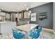Bright dining area with modern lighting, stylish blue chairs, and gray walls adjacent to the kitchen at 6317 Brevada Ln, Apollo Beach, FL 33572