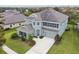 Two-story home showcasing its architectural beauty with blue exterior, a well-manicured lawn, and elegant landscaping at 6317 Brevada Ln, Apollo Beach, FL 33572