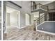 Grand foyer with high ceilings, wood-look tile flooring, staircase, and open entryway to other rooms at 6317 Brevada Ln, Apollo Beach, FL 33572