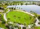 Expansive green space surrounded by palm trees, walking paths, and a scenic lake in a planned community at 6317 Brevada Ln, Apollo Beach, FL 33572
