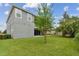 Spacious backyard with a gray house and green grass at 6317 Brevada Ln, Apollo Beach, FL 33572