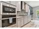 Modern kitchen with stainless steel appliances, gray cabinets, and a stylish backsplash at 6317 Brevada Ln, Apollo Beach, FL 33572