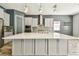 Bright kitchen features a large center island, stainless steel hood, and sleek gray cabinets at 6317 Brevada Ln, Apollo Beach, FL 33572