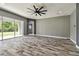 Bright living room features wood tile flooring, large sliding glass door, and modern ceiling fan at 6317 Brevada Ln, Apollo Beach, FL 33572