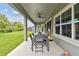 Covered patio with a ceiling fan, outdoor dining set, and views of a lush green lawn at 6317 Brevada Ln, Apollo Beach, FL 33572