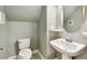 Powder room featuring a pedestal sink, decorative mirror, and neutral color scheme at 6317 Brevada Ln, Apollo Beach, FL 33572