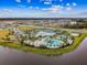 Aerial view of a community resort-style pool with a clubhouse and tennis courts at 6317 Brevada Ln, Apollo Beach, FL 33572