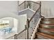 A wooden staircase with ornate railing, and gray accent wall with dining area to the side at 6317 Brevada Ln, Apollo Beach, FL 33572