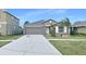 Gray house with a two-car garage and landscaped lawn at 7231 Somerset Pond Dr, Ruskin, FL 33573