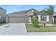 Gray house with a two-car garage and landscaped lawn at 7231 Somerset Pond Dr, Ruskin, FL 33573