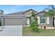 Gray house with a two-car garage and landscaped lawn at 7231 Somerset Pond Dr, Ruskin, FL 33573