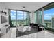 Modern living room boasts floor-to-ceiling windows with city views, sleek furniture, and monochrome decor at 777 N Ashley Dr # 2613, Tampa, FL 33602