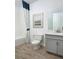 Modern bathroom with gray vanity, tile flooring, and geometric shower curtain at 847 Ruddy Quail Pl, Sun City Center, FL 33573