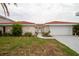 House exterior showcasing a two-car garage and a walkway to the entryway at 9830 San Sierra Way, Port Richey, FL 34668
