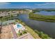 Aerial view of community pool, tennis courts, and a tranquil lake setting at 10036 63Rd N Ave # 23, St Petersburg, FL 33708
