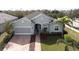 Single-story home with light green exterior, screened porch, and brick driveway at 212 Shell Creek Ct, Apollo Beach, FL 33572