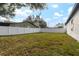 Large grassy backyard with a white vinyl fence at 22227 River Rock Dr, Land O Lakes, FL 34639