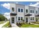 A modern townhome exterior with a well-manicured lawn and a stylish black awning over the front door at 3402 E 28Th Ave # 1, Tampa, FL 33605