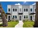 A modern townhome featuring a well-manicured lawn and stylish black awning over the front door at 3402 E 28Th Ave # 1, Tampa, FL 33605