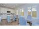 Modern kitchen with white cabinets, blue island, and a view to the backyard at 3731 Tea Leaf Aly, Land O Lakes, FL 34638