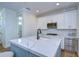 Modern kitchen with white cabinets and a blue island with white quartz countertops at 3731 Tea Leaf Aly, Land O Lakes, FL 34638