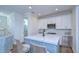 Modern kitchen features white cabinets, a quartz island, and stainless steel appliances at 3731 Tea Leaf Aly, Land O Lakes, FL 34638