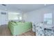 Open living area with green sectional sofa and floral accent chairs at 3731 Tea Leaf Aly, Land O Lakes, FL 34638