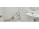Powder room with tile floors, a modern toilet, and a pedestal sink at 4187 Feldspar Ln, Spring Hill, FL 34609
