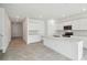 Bright kitchen with stainless steel appliances, white cabinets, an island, and tile flooring at 4187 Feldspar Ln, Spring Hill, FL 34609