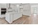 Modern white kitchen with island, stainless steel appliances, and subway tile backsplash at 4187 Feldspar Ln, Spring Hill, FL 34609