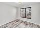 Bright bedroom with wood-look flooring and large window at 4530 Pinebrook Cir # 208, Bradenton, FL 34209