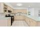 L-shaped kitchen with light cabinets and stainless steel appliances at 5344 Lowell Ave, Spring Hill, FL 34609