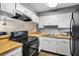 Galley kitchen with wood countertops and black appliances at 9209 Seminole Blvd # 75, Seminole, FL 33772
