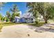 Light blue house with a metal roof, large yard, and a spacious concrete driveway at 106 E Calhoun St, Plant City, FL 33563