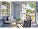 Relaxing front porch with wicker seating and glass-top coffee table at 106 E Calhoun St, Plant City, FL 33563