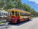 Red and yellow trolley on the street, offering tours of the local area at 1460 Gulf Blvd # 210, Clearwater Beach, FL 33767