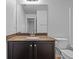 Bathroom with granite countertop, dark brown vanity, and a white toilet at 2811 Maple Brook Loop, Lutz, FL 33558