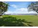 Expansive backyard with lush green lawn, waterfront views, and a charming fence line at 306 Blanca Ln, Tampa, FL 33606