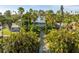 Two-story house with driveway, surrounded by lush tropical landscaping at 3302 E Maritana Dr, St Pete Beach, FL 33706