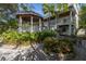 Beautiful backyard featuring a gazebo, stone fountain, lush landscaping, and two-story home at 3302 E Maritana Dr, St Pete Beach, FL 33706