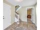 Welcoming foyer featuring tile flooring, staircase, and access to other rooms in the house at 3302 E Maritana Dr, St Pete Beach, FL 33706