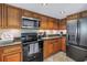 Well-equipped kitchen boasts dark appliances, granite countertops, and wood cabinetry at 3302 E Maritana Dr, St Pete Beach, FL 33706