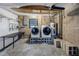 Utility room features modern washer and dryer on risers, workbench, and storage space at 3302 E Maritana Dr, St Pete Beach, FL 33706